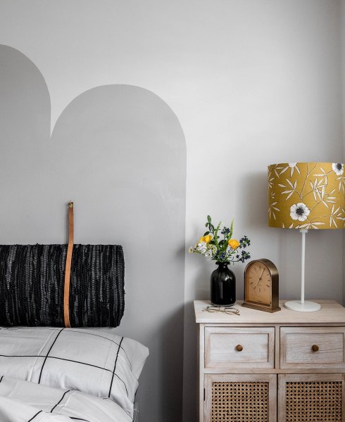 Upholstered headboard and yellow bedside table lamp